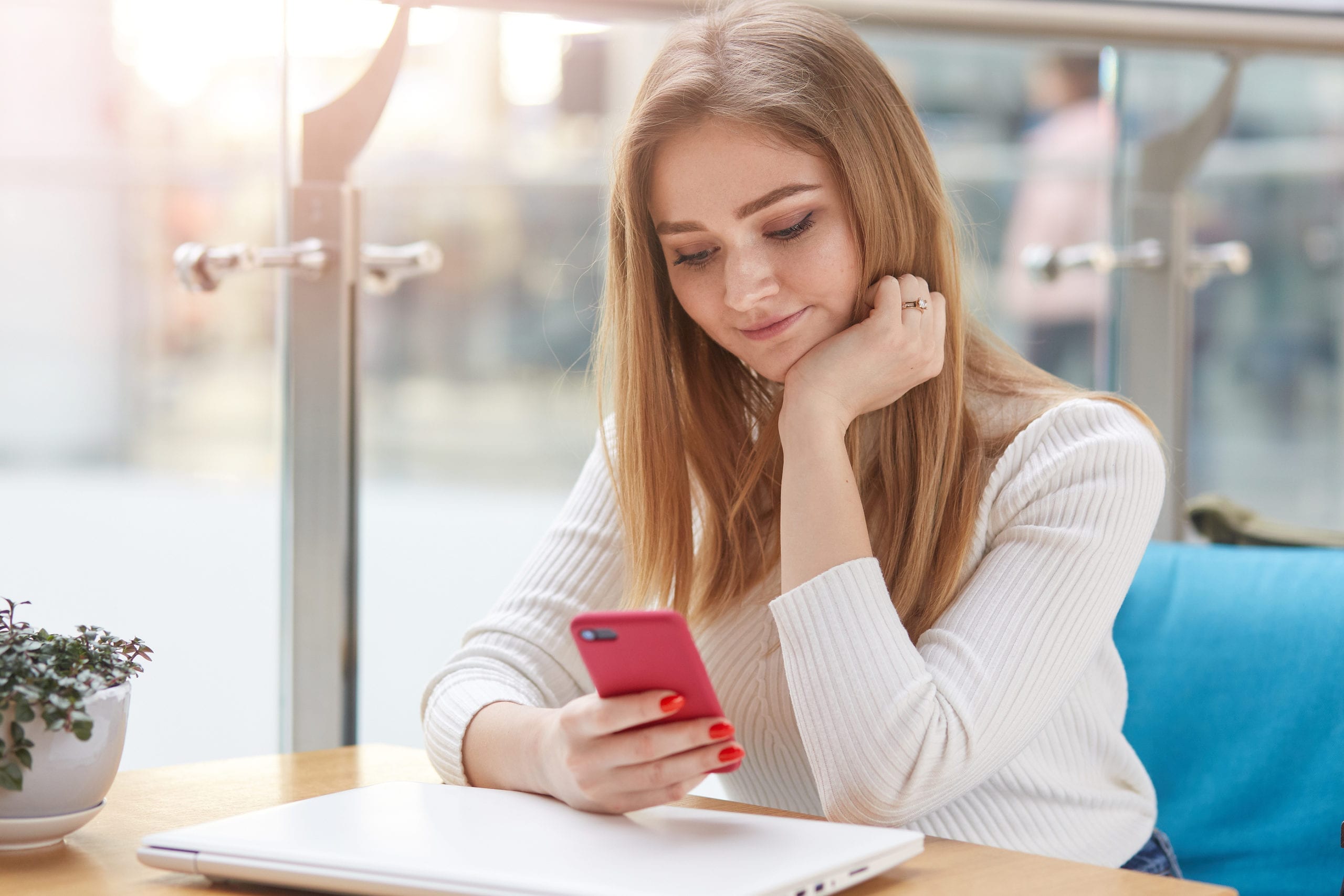 Close Up Portrait Of Charming Female Using Mobile Phone During B