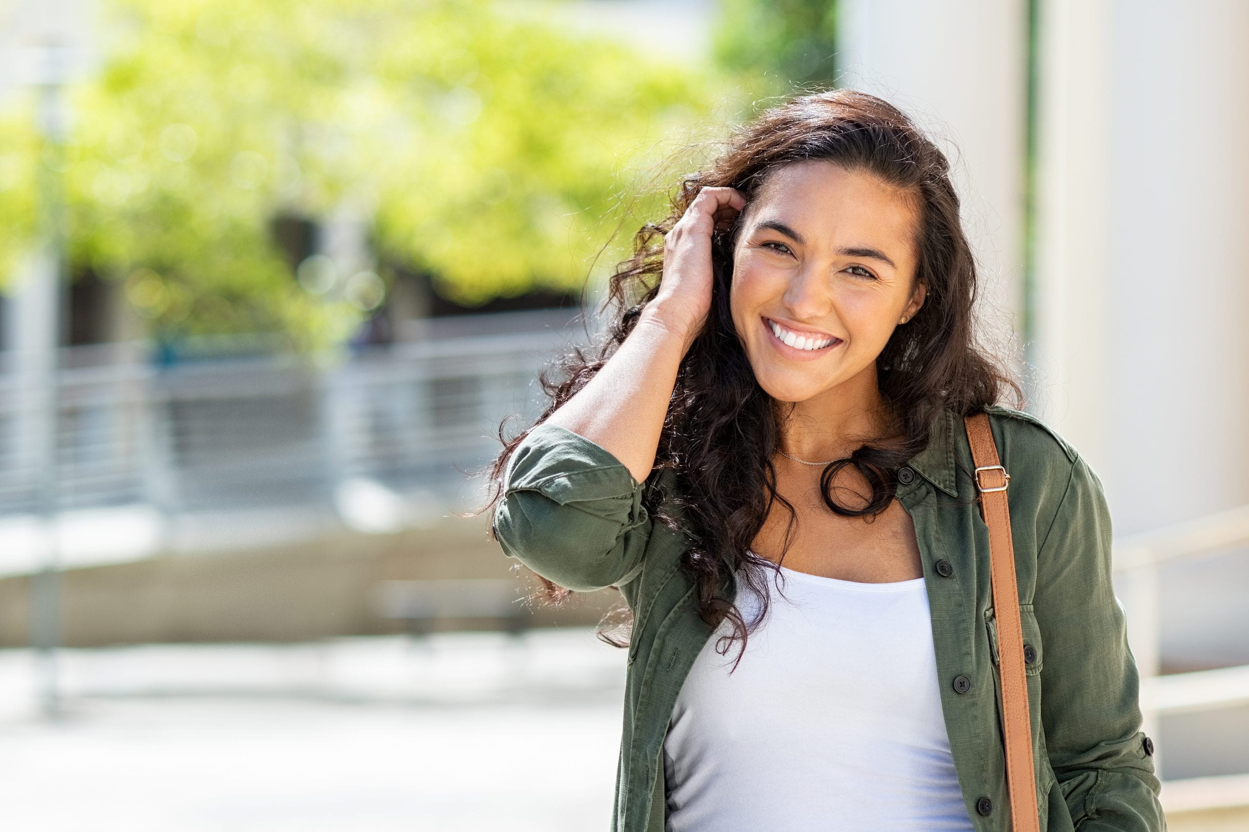 Happy young beautiful woman walking on the street. Portrait of c